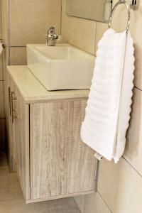 a bathroom with a sink and a white towel at Zoe Bush Lodge in Pretoria