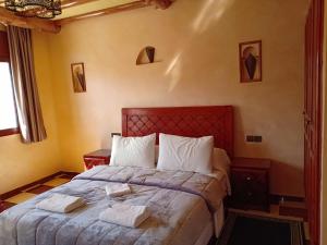 ein Schlafzimmer mit einem Bett mit zwei Handtüchern darauf in der Unterkunft hotel arganier tafraoute in Tafraout