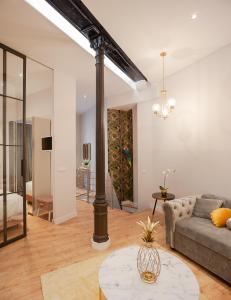 uma sala de estar com um sofá e uma mesa em MIMA Suites Chueca em Madri