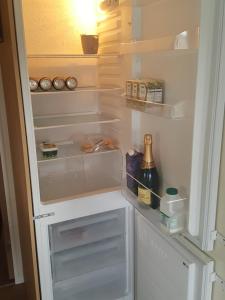 a refrigerator with its door open and a bottle of champagne at Rydal 38 Haven lakeland LA11 7LT in Flookburgh