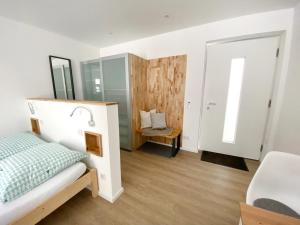 1 dormitorio con cama y espejo en AllgäuLiebe en Oy-Mittelberg
