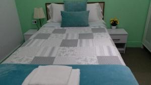 a bedroom with a large bed with blue and green walls at Pensión Mar Azul in Santiago de Compostela
