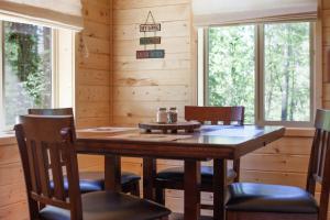 comedor con mesa de madera y sillas en The Ridge At Glacier - Luxury Cabins en Coram