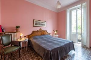 a bedroom with pink walls and a bed and a chair at Elegante Casa Liberty in Milan