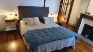 a bedroom with a large bed with a blue blanket at VANILLE CAFE CHOCOLAT in Bagnères-de-Bigorre