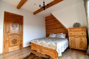 a bedroom with a bed and a wooden door at Apartamenty Rogowcówka in Biały Dunajec