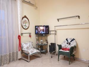 a living room with two chairs and a tv at FMR Oplonti PLINIO B&B in Torre Annunziata