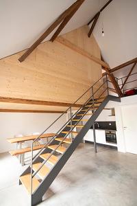a metal and wood staircase in a loft at Historisches Wohnen modern interpretiert in Kirrweiler