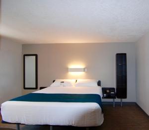 a bedroom with a large white bed and two mirrors at Motel 6-Saanichton, BC - Victoria Airport in Saanichton