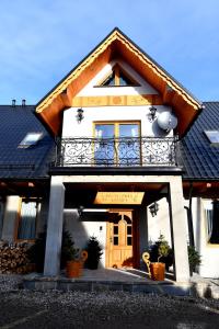 a house with a balcony on the front of it at Apartamenty Rogowcówka in Biały Dunajec