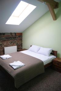 a bedroom with a large bed with two towels on it at Hotel Rover in Lviv