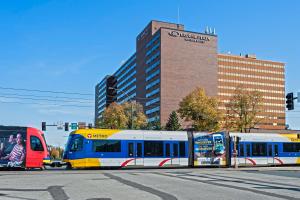a blue and yellow train on a city street at Crowne Plaza Suites MSP Airport in Bloomington