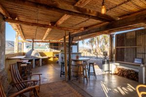 eine Küche mit Holzdecken und Tischen sowie einem Kamin in der Unterkunft 360on62 Farm Cottages in Montagu