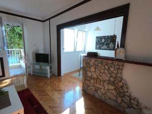 a living room with a large window and a stone fireplace at moTIVATion apartment in Tivat