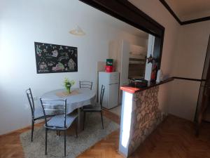 eine Küche mit einem Tisch und Stühlen sowie einem Kühlschrank in der Unterkunft moTIVATion apartment in Tivat