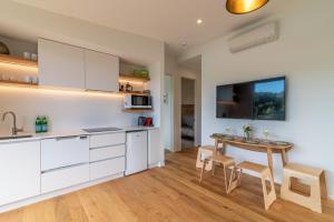 a kitchen with white cabinets and a table and chairs at Treetop Retreat - Takamatua Holiday Home in Takamatua Bay