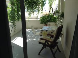 a table and a chair sitting on a balcony at Apartments Leut in Drasnice