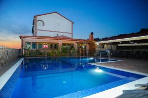 a swimming pool in front of a house at Apartments BRANO - with swimming pool in Novalja