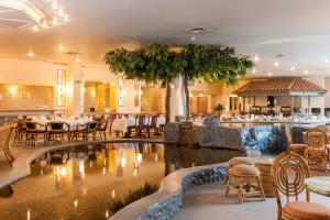 a restaurant with a pool and tables and chairs at Wyndham Garden Donaueschingen in Donaueschingen