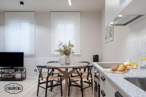 une cuisine avec une table, des chaises et un évier dans l'établissement Retiro Chic - Apartamento de 1 dormitorio, à Madrid 18 autres photos