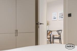 Cette chambre dispose de portes blanches, d'une table et d'une salle à manger. dans l'établissement Retiro Chic - Apartamento de 1 dormitorio, à Madrid