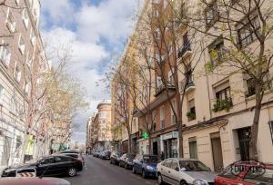 une rue avec des voitures garées sur les côtés des bâtiments dans l'établissement Retiro Chic - Apartamento de 1 dormitorio, à Madrid