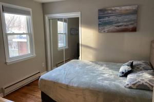 a bedroom with a bed and two windows at The Nottawa Gem, Blue Mountain & Collingwood in Nottawa