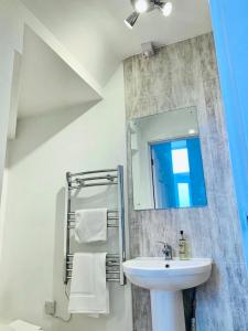 a white bathroom with a sink and a mirror at Ferry House in Pembroke Dock