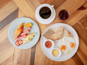 a table with two plates of breakfast foods and a cup of coffee at Selina Cancun Downtown in Cancún