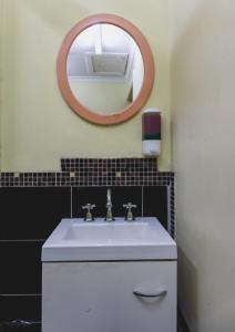 La salle de bains est pourvue d'un lavabo blanc et d'un miroir. dans l'établissement Royal Derby Hotel, à Melbourne