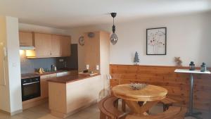 a kitchen with a wooden table and a small table with a wooden table at Très bel appartement pied de pistes 6 pers Serre Chevalier Chantemerle in Saint-Chaffrey