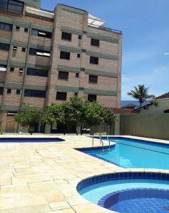 a swimming pool in front of a building at APARTAMENTO PRAIA CENTRO in Ubatuba