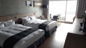 ein Hotelzimmer mit 2 Betten und einem Tisch in der Unterkunft Khokak Panoramas Hotel in Gukeng