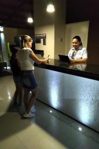 a woman standing at a counter in a store at Brisas de San Lorenzo Posada Lounge in Porlamar