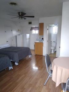 1 dormitorio con 1 cama, mesa y silla en Nautical Motel, en Hampton