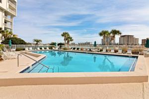 a swimming pool with lounge chairs and a building at Dolphin Point in Destin