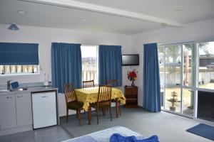 a kitchen and dining room with a table and chairs at Hibiscus Bed & Breakfast in Waihi Beach