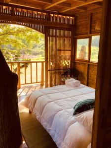 sypialnia z dużym łóżkiem w drewnianym domku w obiekcie Casa del Árbol Colombia w mieście Tobia