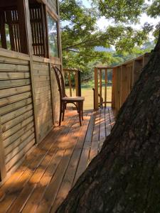 a wooden deck with a chair sitting on top of it at Casa del Árbol Colombia in Tobia