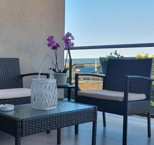 un patio con 2 sillas y una mesa con flores. en Location10 en Palermo