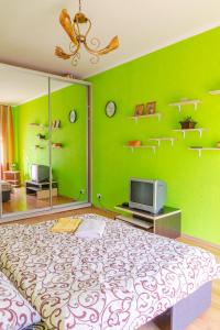 a green room with a large bed and a tv at Квартира по улице Цитадельная 4 in Kyiv