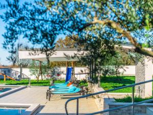 a group of blue lounge chairs next to a pool at Beautiful Villa in Vrsar with Swimming Pool in Vrsar