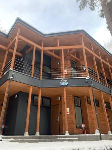 a building with a balcony on top of it at Apartments Hakuba in Hakuba