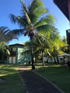 un par de palmeras frente a un edificio en Itacimirim - Quinta das Lagoas Residence, en Itacimirim