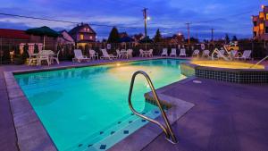 Best Western Cascadia Inn في إيفريت: مسبح كبير مع كراسي وطاولة