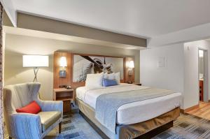 um quarto de hotel com uma cama e uma cadeira em Executive Residency by Best Western Navigator Inn & Suites em Everett
