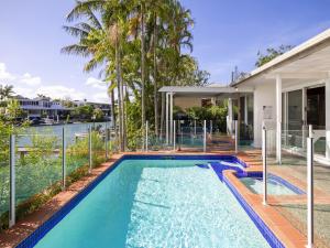 a swimming pool in the backyard of a house at Waterfront on Witta Circle in Noosa Heads