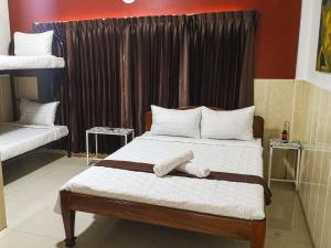 a bed room with a white bedspread and pillows at Route 76 Guest House in Senmonorom
