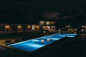 a swimming pool lit up at night in front of a house at Summer Rocker Villa in Ji'an