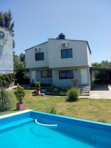a house and a swimming pool in front of a house at Los Ceibos in Villa Carlos Paz